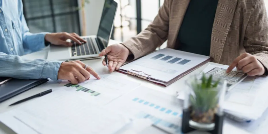 Geschäftspersonen planen Steuern mit Charts und Taschenrechner